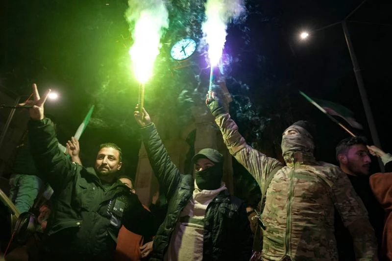 Halep'teki bazı mahallelerin muhalif gruplar tarafından ele geçirilmesini kutlayan İdlib şehrindeki gençler ve muhalif grupların üyeleri, 29 Kasım 2024 / Fotoğraf: AFP